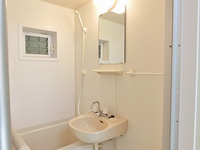 小窓のある浴室です。洗面台部分には鏡と小物ラックがございます。